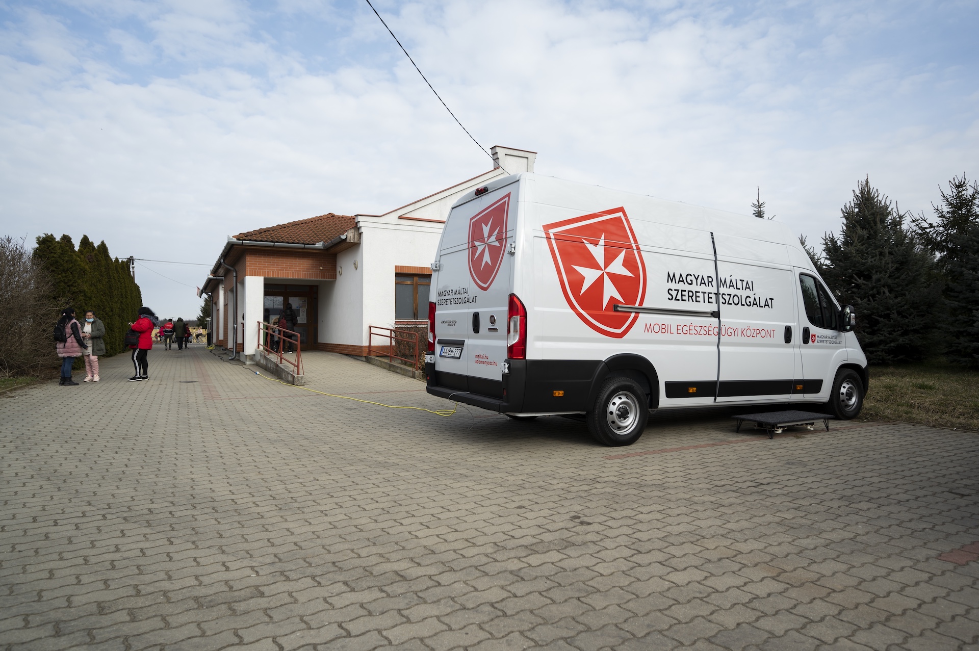 A Magyar Máltai Szeretetszolgálat munkatársai és önkéntesei csoportképen a szűrőbuszok előtt